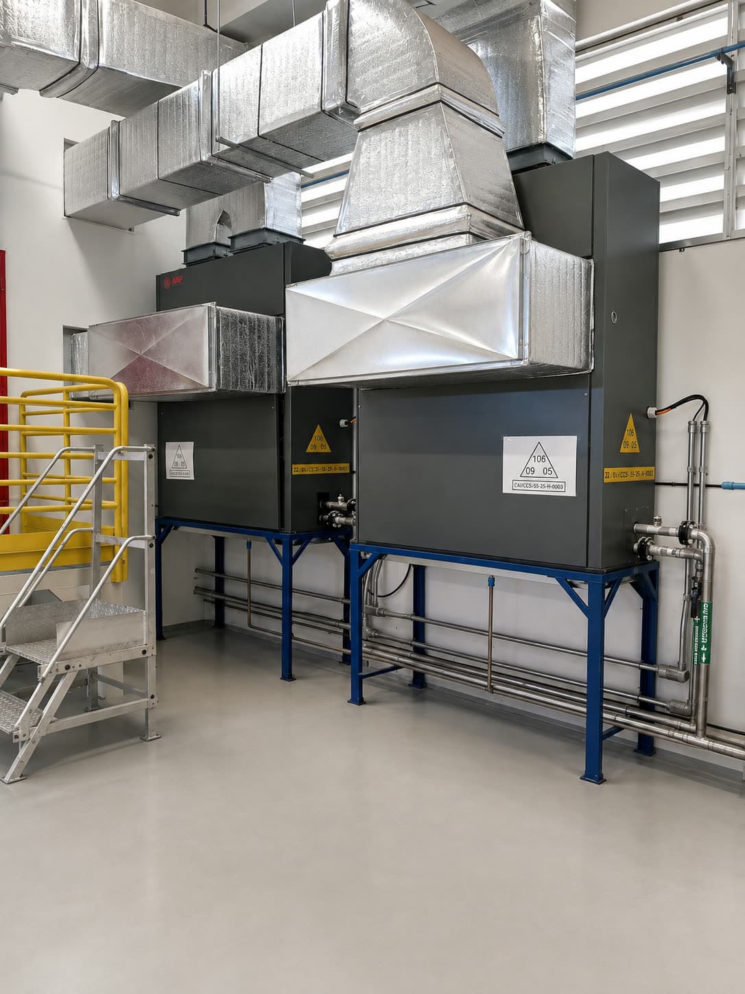 Equipamento de climatização (self-contained/AHU) instalado, com rede de dutos isolados, numa sala técnica industrial