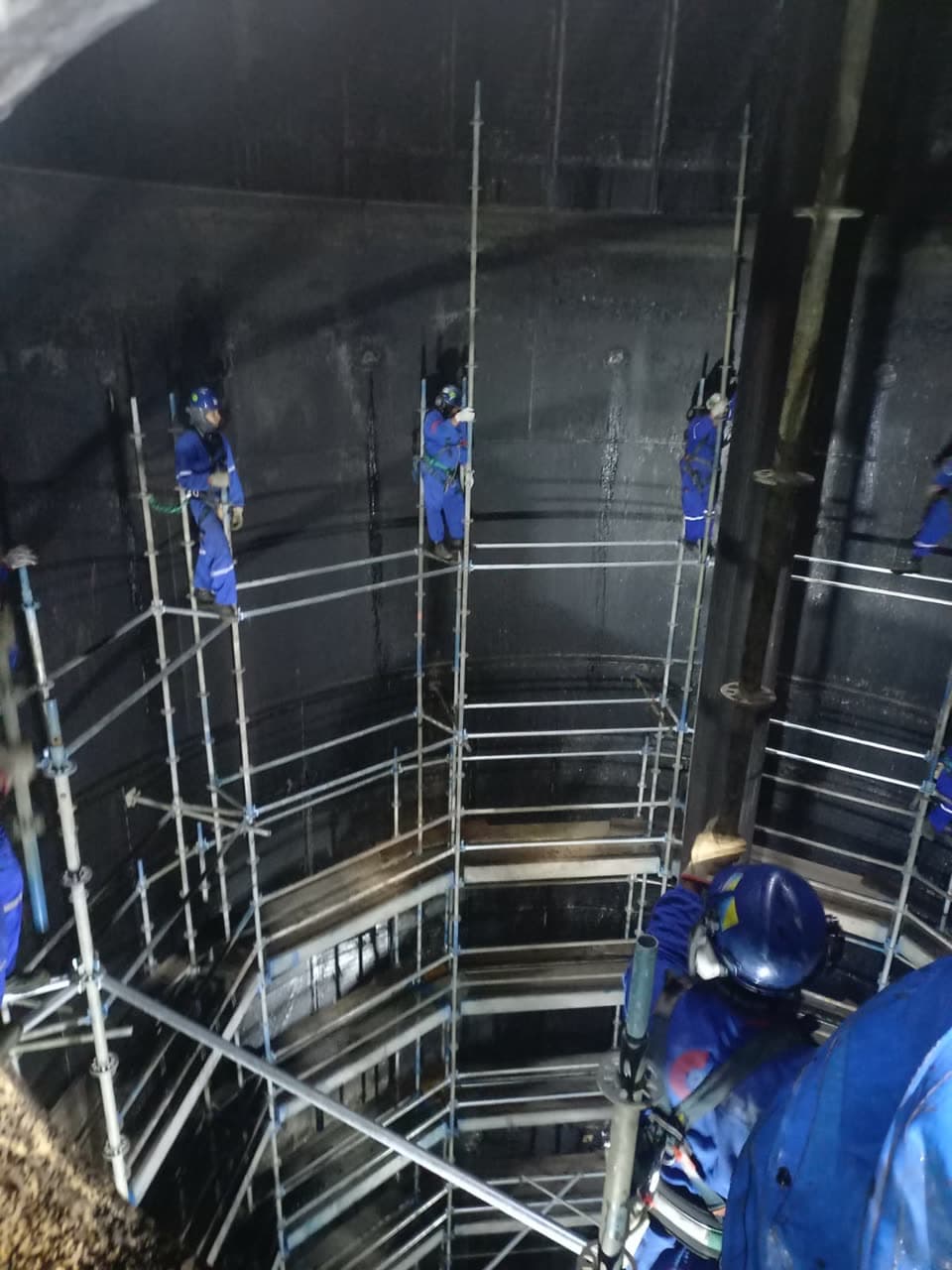 Equipe trabalhando dentro de um tanque